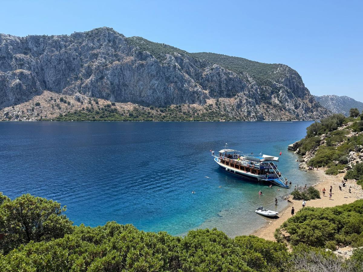 A boat in a pine-fringed cove on the Turkish coast