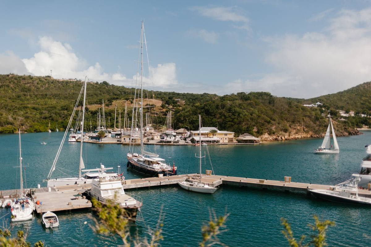 A marina of yachts below green hills