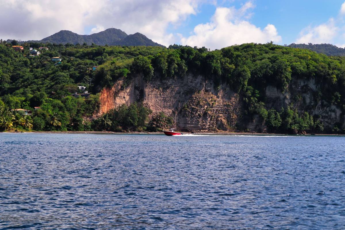 A boat off the green cliffs of the Saint Lucia coastline